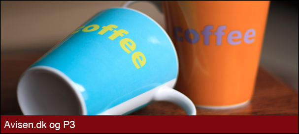 Et liggende blåt kaffekrus foran et stående orange kaffekrus